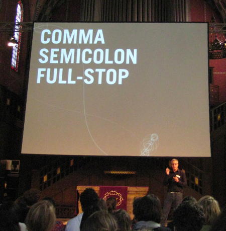 Brendan Dawes speaking at see conference 2011 with a slide saying »Comma, Semicolon, Full Stop« in the background
