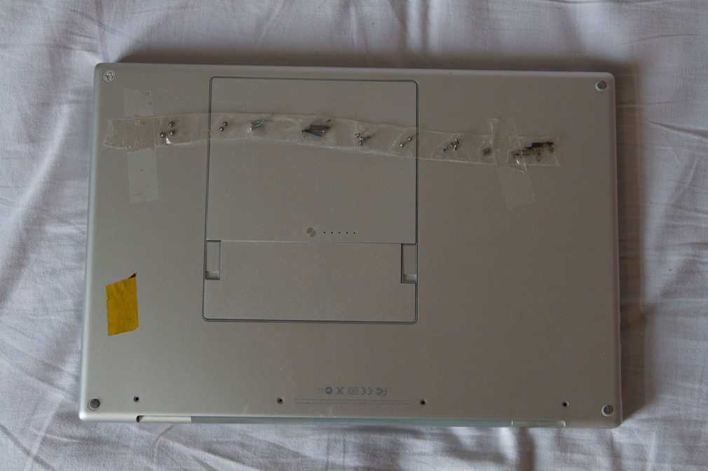 MacBook Pro: view of the bottom case with the removed screws taped on.